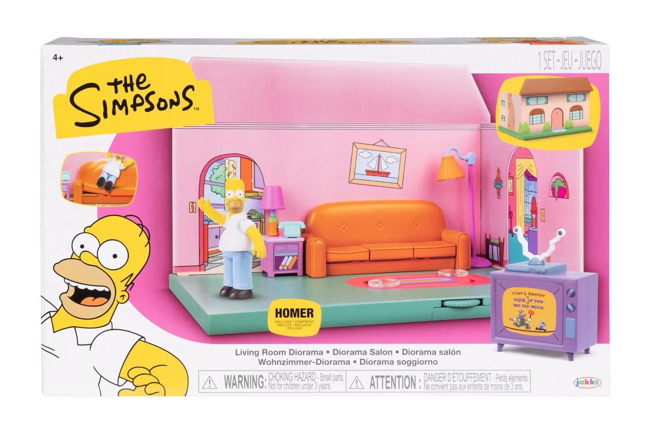 The Simpsons Homer Living Room Diorama toy set in its original retail packaging, featuring a pink and orange living room scene with Homer Simpson, a purple TV, and a small house accessory.